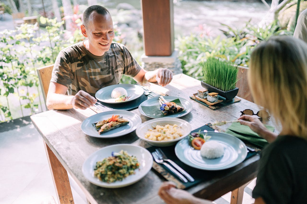 Outdoor dining with a couple enjoying a diverse and colorful meal on a sunny day.